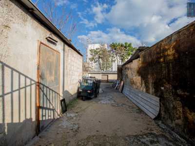 ...accanto al quale si trova un locale ancora aperto. Ci affacciamo per dare un�occhiata e all�interno scoviamo uno spiazzo sul quale � parcheggiato un tre ruote blu. Ad accoglierci � il 60enne Peppino. �Questo deposito � uno dei pochi rimasti attivi su via Oberdan�, ci spiega